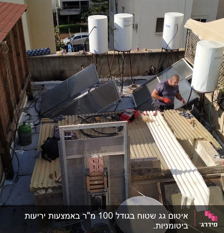 שני אנשים עובדים על גג עם דודי שמש וכלי עבודה